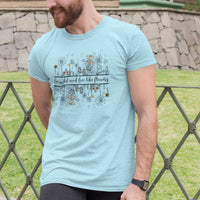 Man wearing Be Wild and Free like Flowers Light Blue Unisex Cotton T-Shirt in front of the house