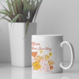 Bloom Your Own Way Floral Design Mug next to a plant